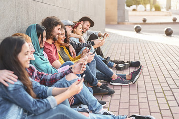 Wall Mural - Group trendy friends using smart mobile phones outdoor - Millennial people having fun with new technology trends smartphone - Youth generation lifestyle and tech addiction social media concept