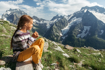 Wall Mural - Child holiding spring flower and enjoying beautiful mountains view