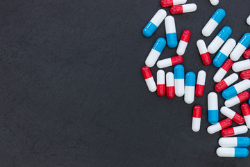 Drugs pills capsules on dark background abstract top view medicine health concept