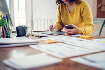 Designer woman drawing a website outline and website ux app development on mobile phone.