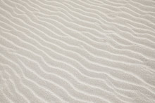 White Sand Dunes Background Texture. Beach And Sand Texture. Pattern Of Sand. Beautiful Sand Dune In Sunrise In The Desert. Steps On The Beach Sand.
