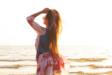 Canvas Print - Young lovely woman wearing beautiful dress is walking by the sea shore