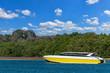 © Ratchapon - The yellow speed boat at sea with blue sky and mountain background