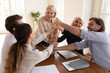 © fizkes - Happy multiracial colleagues stack fists engaged in teambuilding