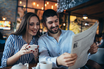 Poster - couple in cafeteria drinking tea reading press