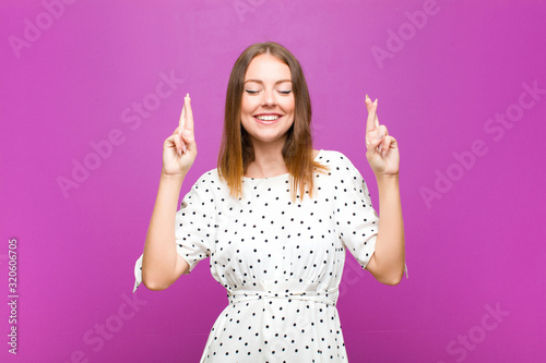 red head pretty woman feeling nervous and hopeful, crossing fingers, praying and Tableau sur Toile