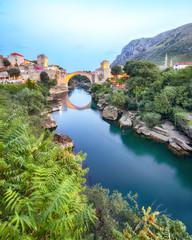 Majestic evening view of Mostar with the Mostar Bridge, houses and minarets, at evening