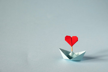 valentine's day greeting card. origami boat with heart flag on glitter blue background romantic, val