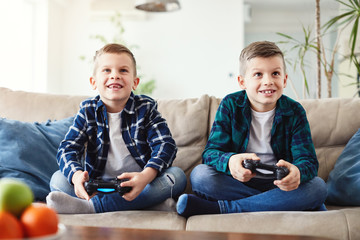 child brother friend having fun playing console laughing happy kid