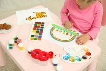 Sticker - Cute little child painting at table in room