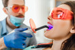 © Тарас Нагирняк - Medicine, dentistry and healthcare concept, dentist male using dental curing UV lamp on teeth of patient.