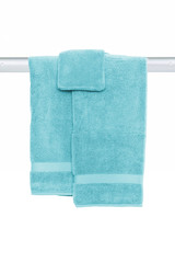 Hanging towels isolated. Closeup of turquoise soft terry bath towels hang on a clothes rail isolated on a white background.