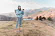 © David Cabrera/ADDICTIVE STOCK - Asian woman taking picture with professional camera of beautiful mountain landscape