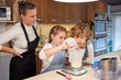 © PHILIPPE DEGROOTE/ADDICTIVE STOCK - Stock photo of children with a woman wearing an apron in a kitchen preparing cupcake and putting the milk in a meter