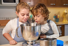 Stock Photo Of A Children With Aprons Looking Inside A Container In The Kitchen And Preparing Cupcake