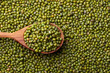 Scattered mung bean. Eco spoon. Mung bean, green moong in a wooden spoon, on black metallic vintage background. Copy space. Black background. 