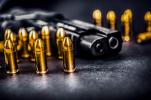 Bullets And Handcuffs. Close-up Of 9mm Pistol. Gun And Weapon With Bullets Amunition On Black Backround.