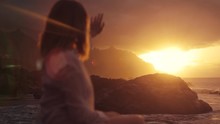 Back view of unrecognizable caucasian woman playing with rays shining through female fingers outdoor sea background sunset close up looking at sun enjoying life time outside nature