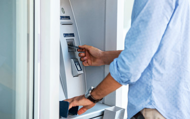 Man using an cash dispenser on the street, close up photo