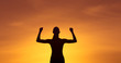 © kieferpix - Strong healthy active female silhouette flexing on sunset sky