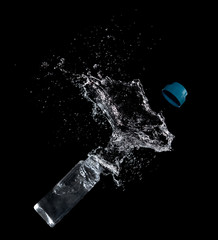 Wall Mural - Bottle of drinking water splashing out isolated on black