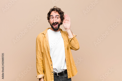 Cuadros en Lienzo young crazy cool man smiling, looking curiously to the side, trying to listen to