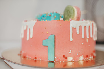 pink beautiful large cake with green number one, decorated with gingerbread and macaroons