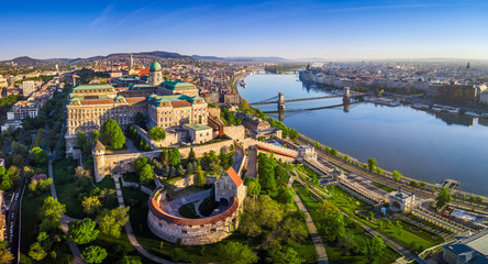 Wall Mural - Budapest, Hungary - Aerial panoramic skyline view of Buda Castle Royal Palace with Szechenyi Chain Bridge, St.Stephen's Basilica, Hungarian Parliament and Matthias Church at sunrise with blue sky