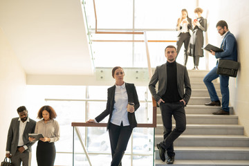 Poster - Ambitious young business people standing on stairs and working as team, company staff concept