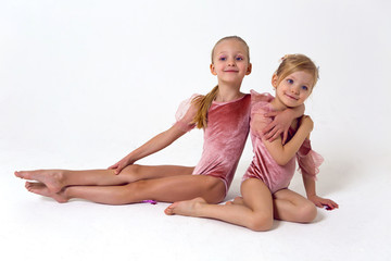 two sisters sitting on a white background