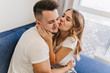 © Look! - Cheerful dark-haired man in white attire spending morning with wife. Adorable blonde girl kissing boyfriend in weekend.