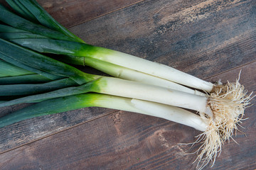 Wall Mural - Fresh raw leeks on wooden table