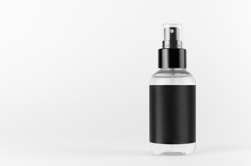 Transparent spray bottle for cosmetics product with black blank label on white background, mock up for branding, advertising, presentation, design.