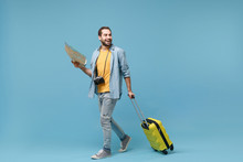 Cheerful traveler tourist man in yellow casual clothes with photo camera isolated on blue background. Male passenger traveling abroad on weekends. Air flight journey concept. Hold suitcase, city map.