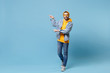 © ViDi Studio - Smiling young hipster guy in fashion jeans denim clothes posing isolated on pastel blue background studio portrait. People emotions lifestyle concept. Mock up copy space. Pointing index fingers aside.