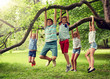 © Syda Productions - friendship, childhood, leisure and people concept - group of happy kids or friends hanging on tree and having fun in summer park