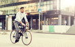 © Syda Productions - lifestyle, transport and people concept - young man with headphones riding bicycle on city street