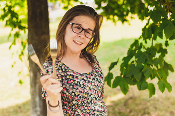 Happy woman playing with kitchen forks outside