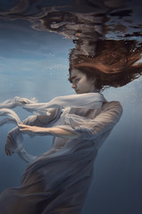 Wall Mural - Portrait of a girl in a blue dress under water