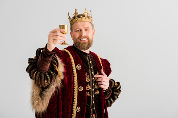 smiling king with crown holding cup isolated on grey