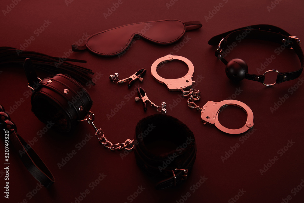 sex toys in dark lighting on red background Stock Photo | Adobe Stock