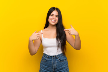 Wall Mural - Young teenager Asian girl over isolated yellow background proud and self-satisfied