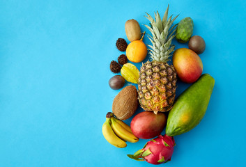 food, summer and healthy eating concept - many different exotic on blue background