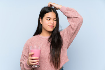 Wall Mural - Young teenager Asian girl with strawberry milkshake having doubts and with confuse face expression