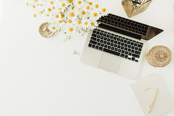 Wall Mural - Home office desk workspace with laptop, chamomile daisy flowers bouquet and notebook on white background. Flat lay, top view minimal freelancer work concept with copy space mockup.
