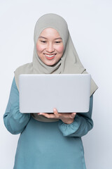 Wall Mural - Muslim woman using a laptop with facial expression.