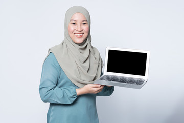 Wall Mural - Muslim woman using a laptop with facial expression.