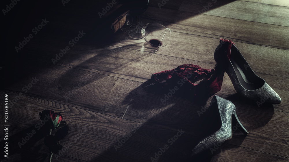 Low key photography of red wine glasses and rose with high heel and panties thrown on the floor  romantic erotic lovers night - obrazy, fototapety, plakaty 