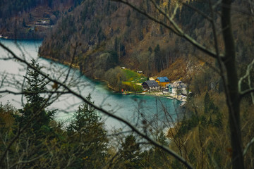 Wall Mural - moody country side farm top view village buildings on lake waterfront shore line nature environment scenery picture through trees bare bare branches autumn season time