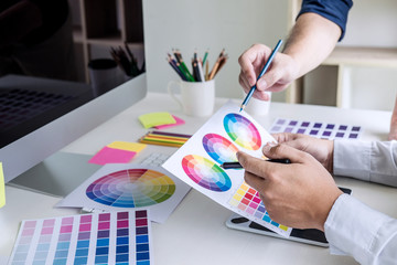 Aufkleber - Two colleague creative graphic designer working on color selection and color swatches, drawing on graphics tablet at workplace with work tools and accessories